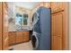 A laundry room with stacked washer and dryer and a utility sink under a window at 881 Kirby Ct, Watkins, CO 80137