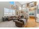 Open-concept living room with natural light, comfortable seating, and a staircase at 881 Kirby Ct, Watkins, CO 80137