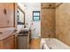 Rustic bathroom with a vessel sink, wooden accents, and tiled shower-tub combination at 1375 Perry St, Denver, CO 80204