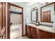 Bathroom with double vanity, dark cabinets and a door leading to a bathtub and shower at 10058 Lewis St, Broomfield, CO 80021