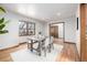 Bright dining room with hardwood floors, a wooden table and bench, illuminated by natural light from the adjacent window at 10058 Lewis St, Broomfield, CO 80021