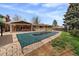 Spacious backyard featuring a covered patio, in-ground pool covered with a safety cover, and mature trees at 13464 W Virginia Dr, Lakewood, CO 80228