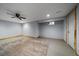 Large basement area with a ceiling fan, small window, and wood-trimmed door adding character to the space at 13464 W Virginia Dr, Lakewood, CO 80228