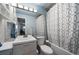 Bright bathroom featuring a modern vanity, a large mirror, and a bathtub with a stylish shower curtain at 13464 W Virginia Dr, Lakewood, CO 80228