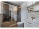 Bathroom featuring a glass-enclosed shower, sink, and toilet with neutral tile and white walls at 13464 W Virginia Dr, Lakewood, CO 80228