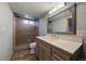 Contemporary bathroom with a glass shower, a large vanity, and a stylish mirror at 13464 W Virginia Dr, Lakewood, CO 80228