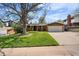 Charming ranch-style house with a two-car garage and a lush front yard with mature trees at 13464 W Virginia Dr, Lakewood, CO 80228