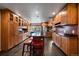 Elegant kitchen featuring custom wood cabinetry, a large island with seating, and stainless steel appliances at 13464 W Virginia Dr, Lakewood, CO 80228