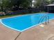 A sunny backyard swimming pool featuring stainless steel ladders at 13464 W Virginia Dr, Lakewood, CO 80228
