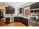 Modern kitchen with dark wood cabinets, granite countertops, and stainless steel appliances at 2771 W 38Th Ave, Denver, CO 80211