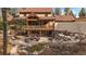 Back of house featuring a covered deck, stone patio, and a water feature at 8090 S Homesteader Dr, Morrison, CO 80465