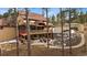 Rear exterior view with covered deck, patio, waterfall, and mature trees at 8090 S Homesteader Dr, Morrison, CO 80465