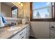 Bright bathroom features marble countertop, white cabinets, and bronze faucet at 8090 S Homesteader Dr, Morrison, CO 80465