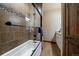 A bathroom with glass enclosed shower, a soaking tub, and brown tiled walls at 8090 S Homesteader Dr, Morrison, CO 80465