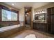 A luxurious bathroom features a soaking tub, a walk-in shower, and custom cabinets at 8090 S Homesteader Dr, Morrison, CO 80465