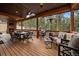 Large covered deck with stone fireplace, dining set, and comfortable lounge furniture at 8090 S Homesteader Dr, Morrison, CO 80465