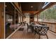 Inviting covered deck features a stone fireplace, outdoor seating, and forest views at 8090 S Homesteader Dr, Morrison, CO 80465