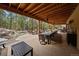 Extensive covered patio with outdoor kitchen, seating, and landscaped waterfall at 8090 S Homesteader Dr, Morrison, CO 80465