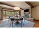Inviting dining room features a stone fireplace, wood beams, large windows, and modern chandelier at 8090 S Homesteader Dr, Morrison, CO 80465