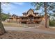 Expansive home with stone accents, large front porch, and elk statue at 8090 S Homesteader Dr, Morrison, CO 80465