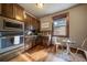 Well-lit kitchen boasts wooden cabinets, stainless steel appliances, mosaic backsplash, and cozy breakfast nook at 8090 S Homesteader Dr, Morrison, CO 80465