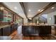Spacious kitchen with granite island, hardwood floors, stainless appliances, and cozy fireplace in the background at 8090 S Homesteader Dr, Morrison, CO 80465