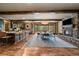 Open-concept living and dining area with a stone fireplace, wood beams, and natural light at 8090 S Homesteader Dr, Morrison, CO 80465
