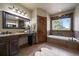 Bright main bathroom features soaking tub, separate shower, dual sinks, and rustic accents for spa-like experience at 8090 S Homesteader Dr, Morrison, CO 80465