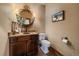 Elegant powder room features a decorative mirror, marble countertop, and warm lighting for a welcoming atmosphere at 8090 S Homesteader Dr, Morrison, CO 80465