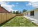 Well-maintained backyard with a grassy lawn, a wooden fence, and side view of the house at 6068 Lee St, Arvada, CO 80004