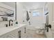 Bathroom features white cabinetry, modern fixtures, and white subway tiled walls at 6068 Lee St, Arvada, CO 80004
