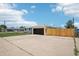 Charming single-story home with a modern garage door, large driveway, and a well-maintained lawn, perfect for suburban living at 6068 Lee St, Arvada, CO 80004