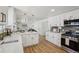 Bright kitchen features white cabinetry, quartz countertops, stainless steel appliances and an eat-in breakfast nook at 6068 Lee St, Arvada, CO 80004