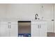 Stylish wet bar with white cabinetry, stainless steel refrigerator, and modern black faucet at 6068 Lee St, Arvada, CO 80004