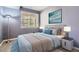 Bright bedroom featuring a bed, nightstands, and artwork at 7150 S Wenatchee Way # D, Aurora, CO 80016