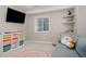 Finished basement playroom featuring shelving with colorful organizers, comfortable seating, and a large TV at 640 E Fremont Pl, Littleton, CO 80122