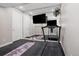 Finished basement workout space featuring mirrored wall, treadmill, TV, rubber flooring, and fitness accessories at 640 E Fremont Pl, Littleton, CO 80122