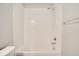 Modern bathtub with new shower head and tile surround at 16203 E 47Th Pl, Denver, CO 80239