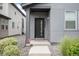 A welcoming entrance of the house features a dark door and neatly maintained landscaping at 16203 E 47Th Pl, Denver, CO 80239