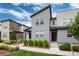 Modern gray townhouses with tidy landscaping and a welcoming walkway under a blue sky at 16203 E 47Th Pl, Denver, CO 80239