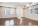 An empty living room with hardwood floors and large windows, filled with plenty of natural light at 16203 E 47Th Pl, Denver, CO 80239