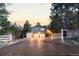 Beautiful front exterior with a three-car garage, white fence, and lush landscaping, set against a scenic sky at 7841 Deertrail Dr, Parker, CO 80138