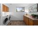 Functional laundry room with modern appliances, cabinetry, and tile flooring at 7841 Deertrail Dr, Parker, CO 80138
