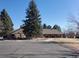 Exterior view of clubhouse and parking lot surrounded by mature trees and grassy areas at 57 Scott S, Broomfield, CO 80020