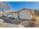 Exterior view of home featuring an attached garage, landscaped front, and a covered front porch at 57 Scott S Dr, Broomfield, CO 80020