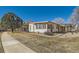 Inviting home showcasing light-colored siding, a covered porch, and a well-manicured lawn with mature trees at 57 Scott S, Broomfield, CO 80020