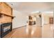 Open-concept living room with wood floors, a fireplace, and a kitchen view at 57 Scott S Dr, Broomfield, CO 80020