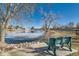 Community pond view from green park bench with ice and clear blue skies and bare trees at 57 Scott S Dr, Broomfield, CO 80020