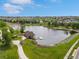 Aerial image of a scenic pond with a dock and gazebo in a neighborhood filled with mature trees and landscaping at 7380 S Shady Grove Way, Aurora, CO 80016