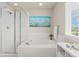 Bright bathroom featuring a soaking tub, separate shower, and a window with natural light at 7380 S Shady Grove Way, Aurora, CO 80016